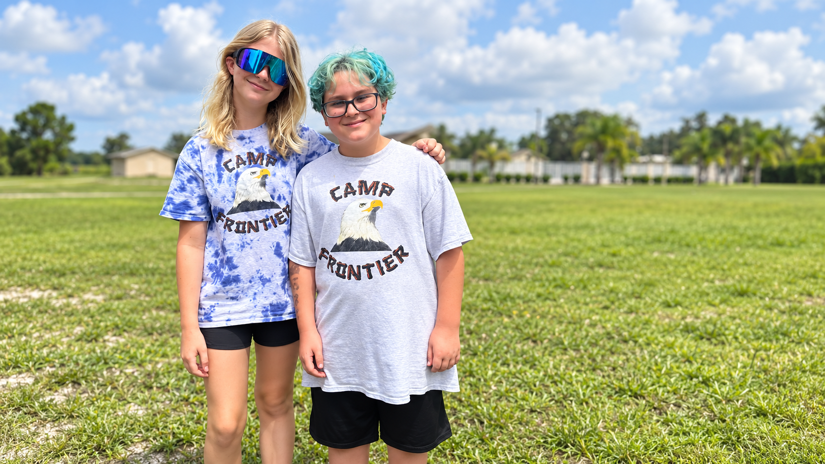 Two smiling Camp Frontier friends wearing their Camp shirts